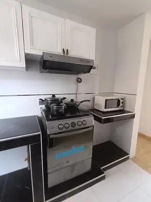 a kitchen with a stove and a microwave at Departamento Vista al Parque Coopip in Lima
