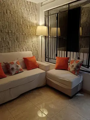 a living room with two white couches and orange pillows at Departamento Vista al Parque Coopip in Lima