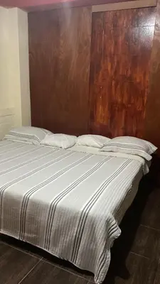a large bed with a wooden headboard in a room at Residencial Misky Dreams in Huánuco