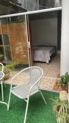 a patio with a chair and a bed in a room at Residencial Misky Dreams in Huánuco