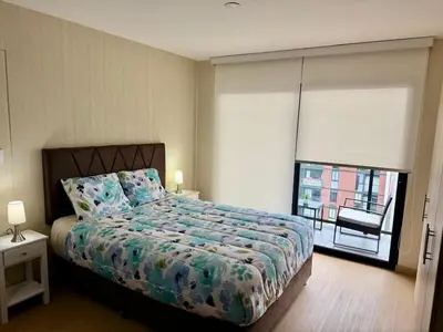 a bedroom with a bed and a large window at Encantador departamento con hermosa vista in Lima