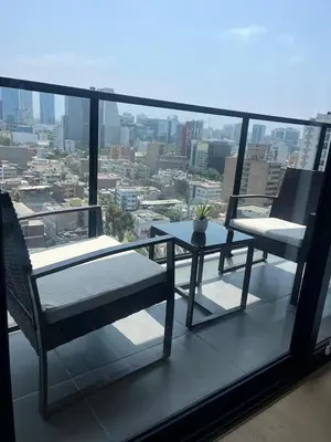 a balcony with a table and two chairs on the roof at Encantador departamento con hermosa vista in Lima