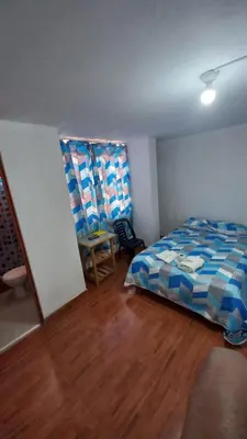 a bedroom with a bed and a wooden floor at Habitación Privada con Entrada Independiente in Ica