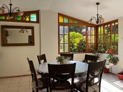 a dining room with a table and chairs and windows at casa de campo en cieneguilla in Cieneguilla