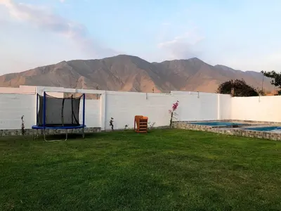 a backyard with a fence and a swimming pool at Kampu Wasi - Casa de Campo in Pachacamac