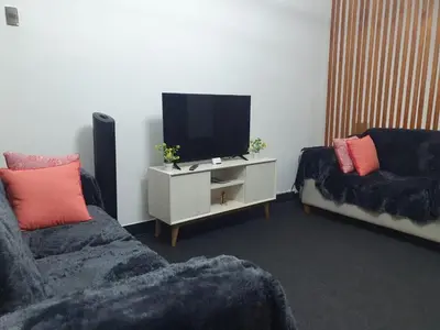 a living room with two couches and a flat screen tv at Beautiful private office in Miraflores in Lima