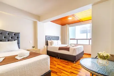 a hotel room with two beds and a table at Hostal Cusco Guest Home in Cusco
