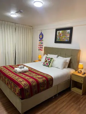 a bedroom with a bed with two stuffed animals on it at Wayna Boutique Hotel in Cusco