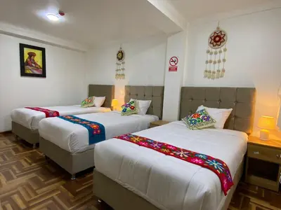 a room with three beds in a room at Wayna Boutique Hotel in Cusco