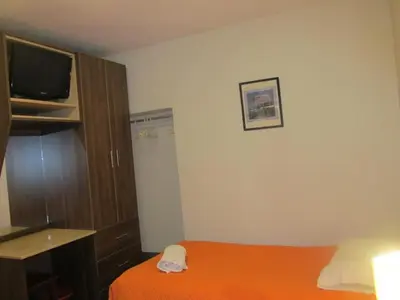 a small room with a bed and a television at Hospedaje M&M in Cusco