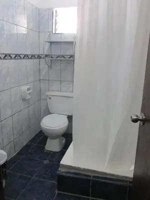 a bathroom with a white toilet and a window at Hospedaje M&M in Cusco