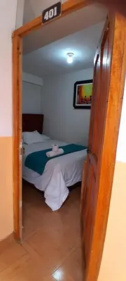 a bedroom with a bed with a sign on the door at Hospedaje M&M in Cusco