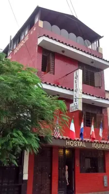 a red building with a hostel sign in front of it at Hostal Iquique in Lima