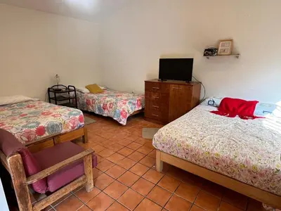 a room with two beds and a tv in it at Country house cieneguilla in Cieneguilla