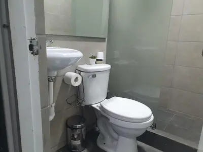 a bathroom with a white toilet and a sink at Hermosa oficina privada en Miraflores in Lima