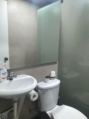 a bathroom with a sink and a toilet and a mirror at Hermosa oficina privada en Miraflores in Lima