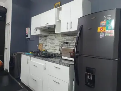 a kitchen with a black refrigerator and white cabinets at Hermosa oficina privada en Miraflores in Lima