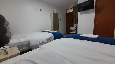a hotel room with two beds and a flat screen tv at La Rinconada de Churin in Churín