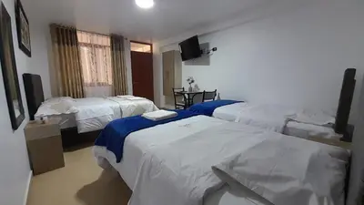 a hotel room with two beds and a television at La Rinconada de Churin in Churín
