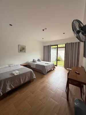 a bedroom with two beds and a table with a fan at The Wismont club & hotel in La Merced