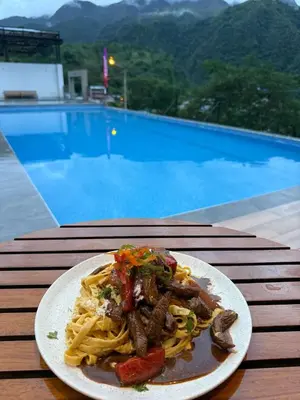 a plate of food on a table next to a pool at The Wismont club & hotel in La Merced