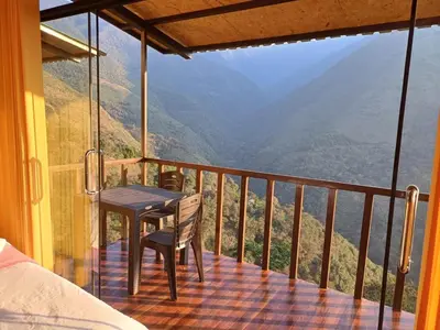 a table and chair on a balcony with a view at Ecoterra Inka Lodge in Quillabamba