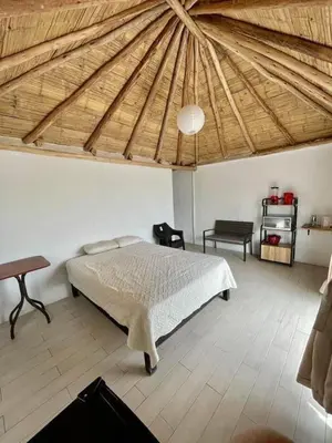 a bedroom with a bed and a wooden ceiling at Bungalows en playa Wakama in San Vicente de Cañete