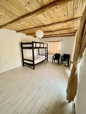 a room with a bed and two chairs in it at Bungalows en playa Wakama in San Vicente de Cañete