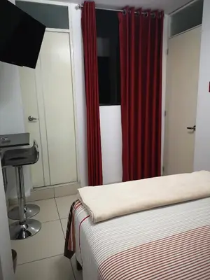 a bedroom with a bed and a red curtain at Hostal Onassis in Lima