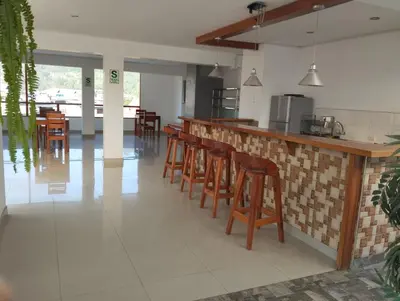 a kitchen with a bar with wooden stools at Hotel Wismont Piñales in La Merced