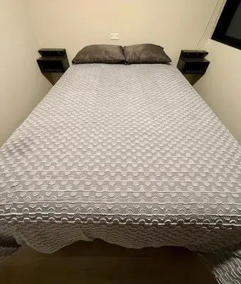 a large bed with a white comforter in a bedroom at Rest, comfort and privacy in San Isidro in Lima