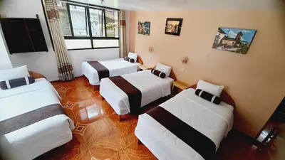 a hotel room with three beds and a window at El Tambo Machupicchu in Machu Picchu