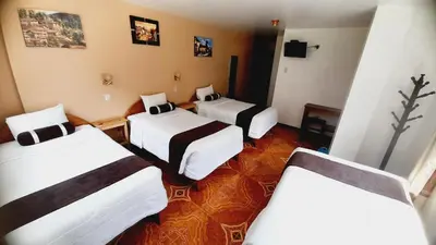 a room with three beds in a room at El Tambo Machupicchu in Machu Picchu