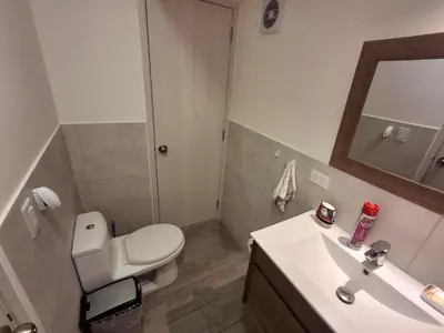 a bathroom with a toilet and a sink and a mirror at Departamento de estreno en San Isidro in Lima
