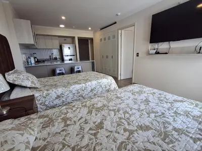 a hotel room with two beds and a kitchen at Departamento de estreno en San Isidro in Lima