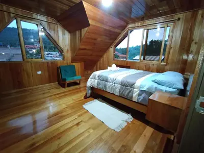 a bedroom with a bed in a wooden cabin at Casa de Machi in Villa Rica