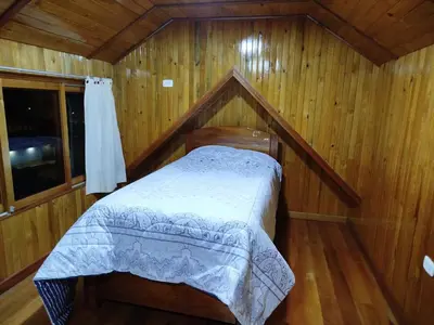 a bedroom with a bed in a wooden cabin at Casa de Machi in Villa Rica