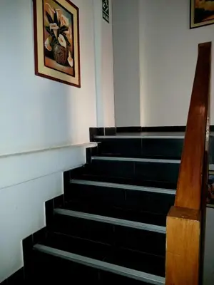 a staircase in a building with a picture on the wall at El Quetzal MachuPicchu in Machu Picchu