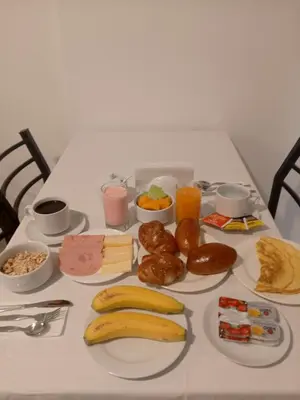 a table topped with plates of breakfast foods and drinks at El Quetzal MachuPicchu in Machu Picchu