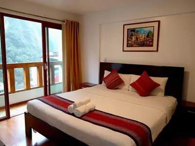a bedroom with a bed with a large window at El Quetzal MachuPicchu in Machu Picchu