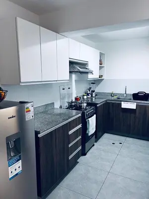 a kitchen with white cabinets and a stove top oven at Hermoso departamento estreno céntrico in Lima