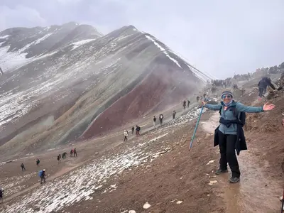 a woman standing on top of a mountain holding a kite at INKA's WALK in Cusco