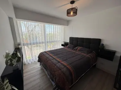 a bedroom with a bed and a large window at Rest and comfort in San Isidro in Lima