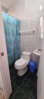 a bathroom with a white toilet and a sink at Curazao in Punta Hermosa