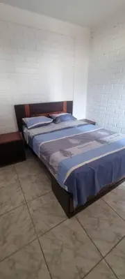 a bed in a room with a blue blanket on it at Curazao in Punta Hermosa
