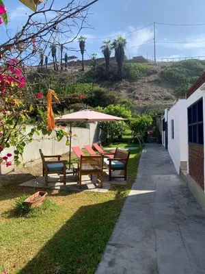 a patio with a table and umbrella and chairs at Sasso alojamiento in Barranca