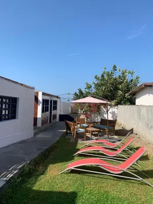 a group of lawn chairs and umbrellas on the grass at Sasso alojamiento in Barranca