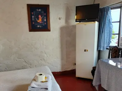 a room with a bed with a towel and a tv at Casa del Gringo in Cieneguilla