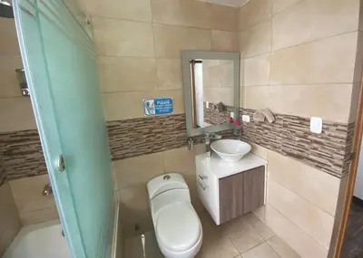 a bathroom with a toilet and a sink and a mirror at Apartamento Tumi Wasi in Lima
