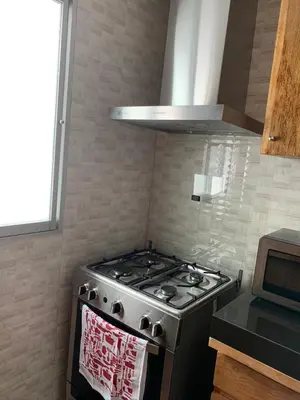 a stove top oven in a kitchen next to a window at Apartamento Tumi Wasi in Lima